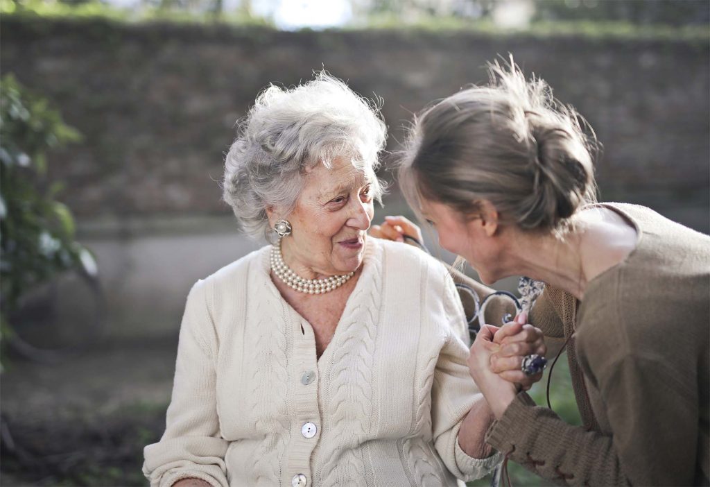 older lady and younger lady talking in garden