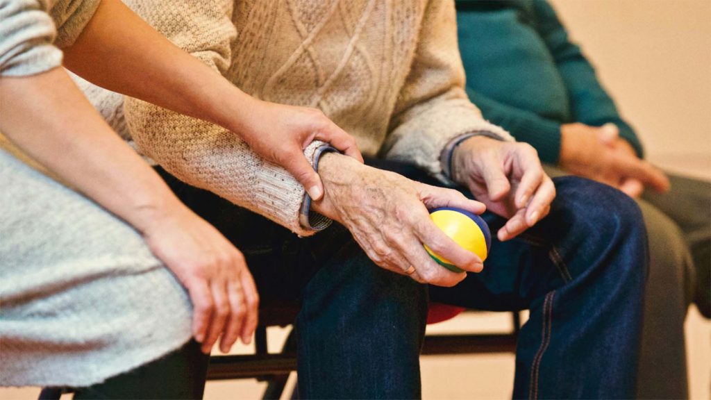older man holding yellow ball