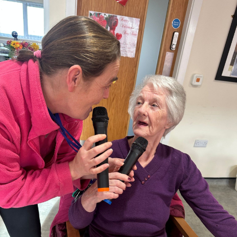 Resident singing with carer