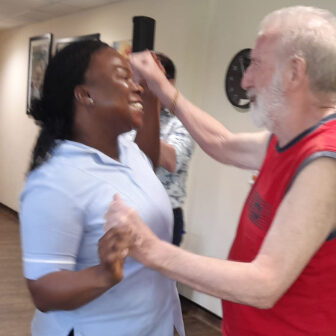 care home resident dancing with staff member
